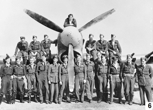 George perched on the propeller of a Typhoon, with squadron personnel gathered below.