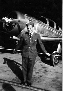 George standing beside a training aircraft.