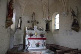 The small chapel interior, with altar, flowers and light from a side window.