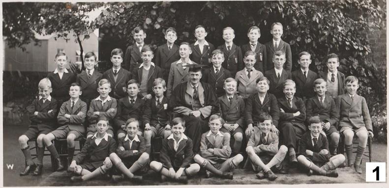 School class arranged in rows, with George highlighted, seated two places to the right of the master.
